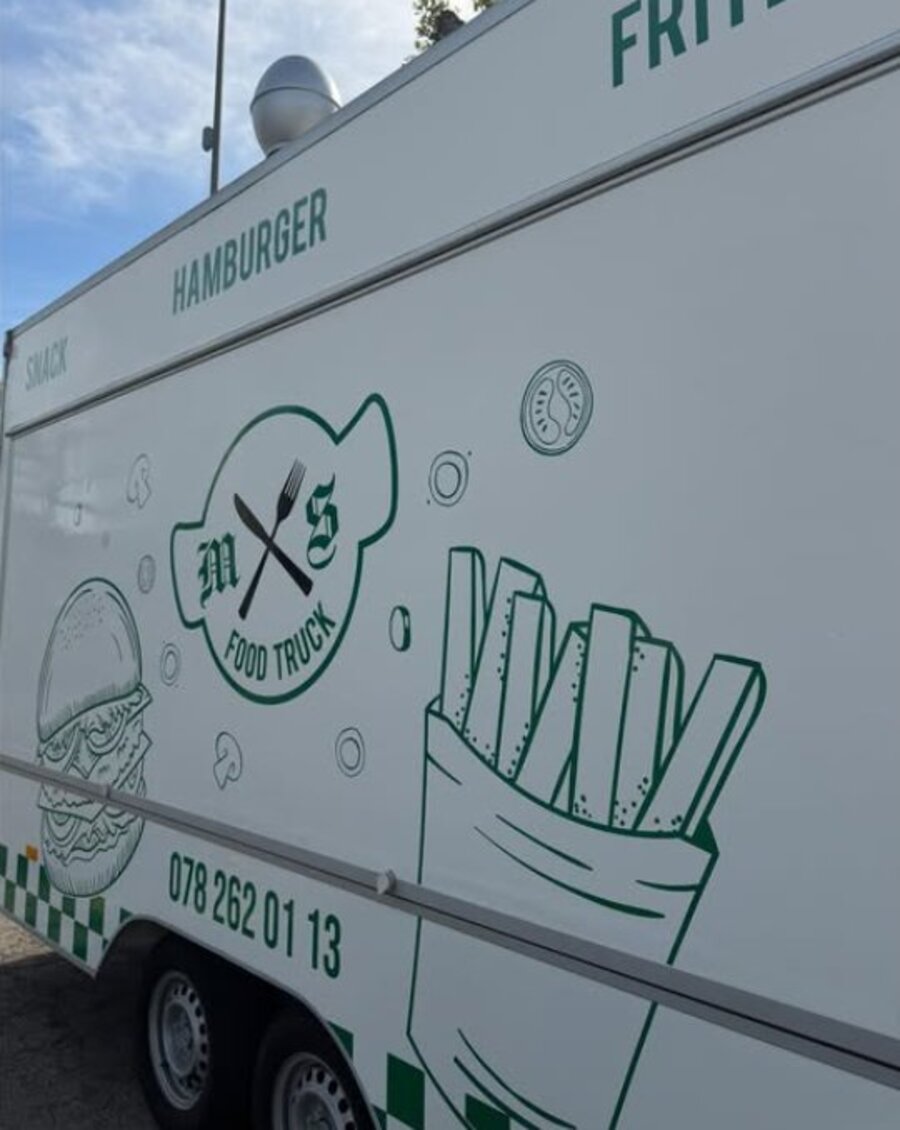 Le camion M&S Food Truck vu de côté, avec ses motifs de burger et frites